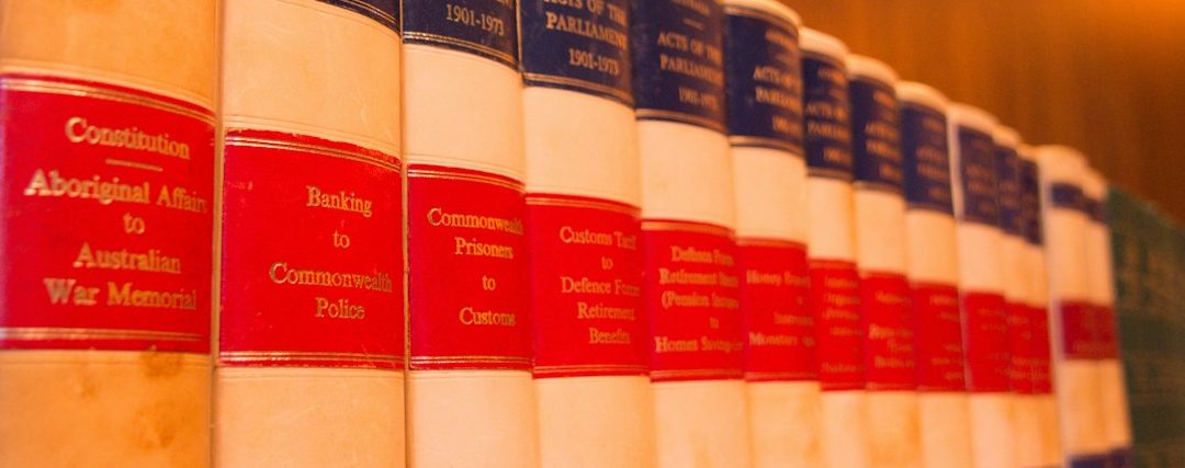 Filas de libros encuadernados en cuero con lomos rojos y dorados.