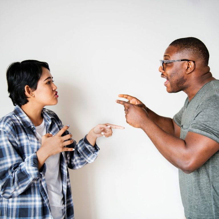 Pelea Familiar Dos personas discutiendo, una señalando y la otra gesticulando con enojo.