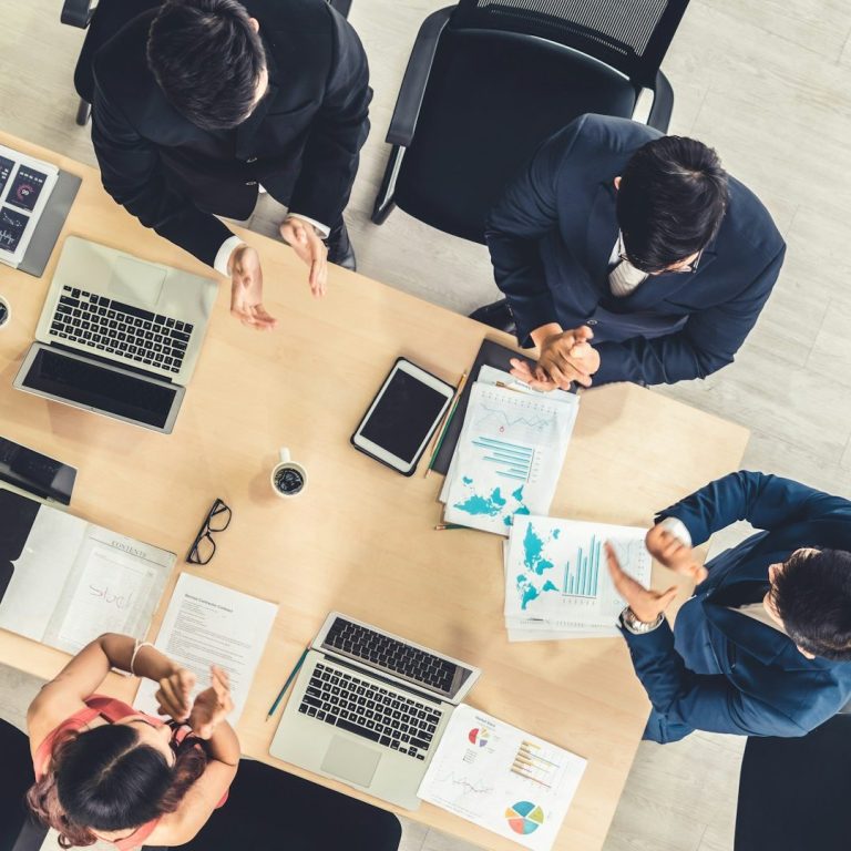 Fases Mediación Grupo de personas en una reunión, analizando documentos sobre una mesa.